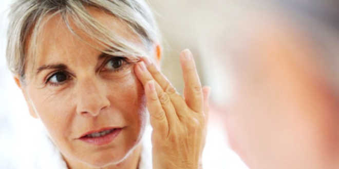 Adult woman putting cream on her face