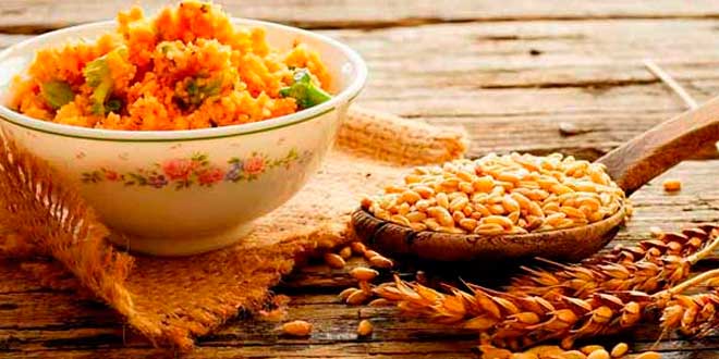 A bowl and a wooden spoon with bulgur A bowl and a wooden spoon with bulgur