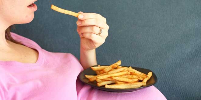 Pregnant woman eating fried chips