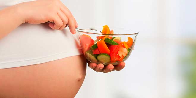 Pregnant woman with a bowl of vegetables