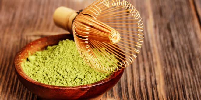 A bowl of matcha powder with a whisk A bowl of matcha powder with a whisk