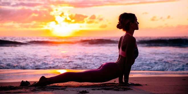 Woman doing yoga at the beach