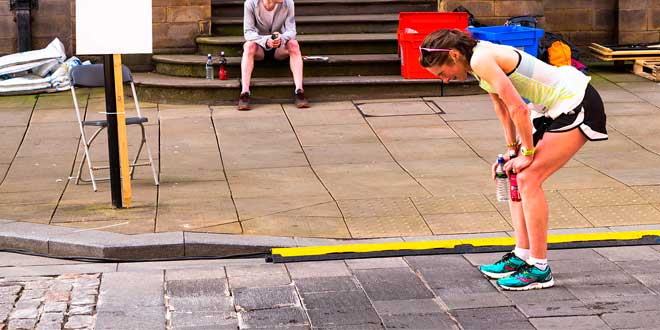 Woman holding two bottles while running