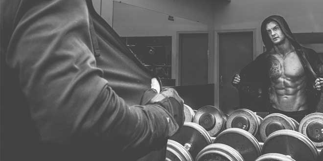 Man looking at himself in a mirror at the gym