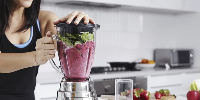 Woman making a smoothie with a blender