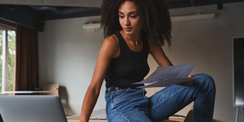 Woman with curls taking a break during work to maintain mental performance Woman with curls taking a break during work to maintain mental performance